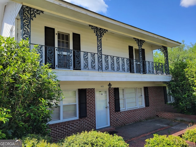 206 New Dr, Claxton, GA 30417 - view of front of house featuring a porch, brick siding, and a balcony