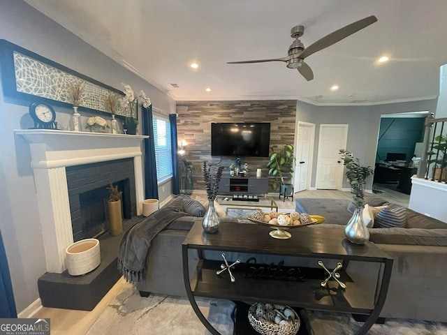 living room with crown molding, a ceiling fan, recessed lighting, and a fireplace