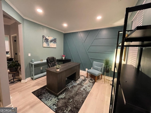 office space with crown molding, a decorative wall, baseboards, recessed lighting, and light wood-type flooring