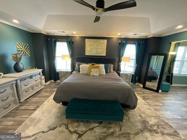bedroom featuring crown molding, multiple windows, wood finished floors, and visible vents