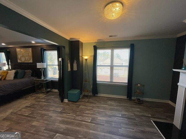 bedroom featuring crown molding, dark wood-style flooring, baseboards, and visible vents