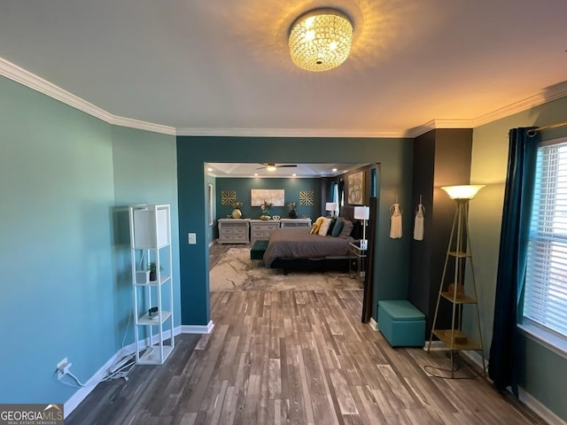 bedroom featuring crown molding, baseboards, and wood finished floors