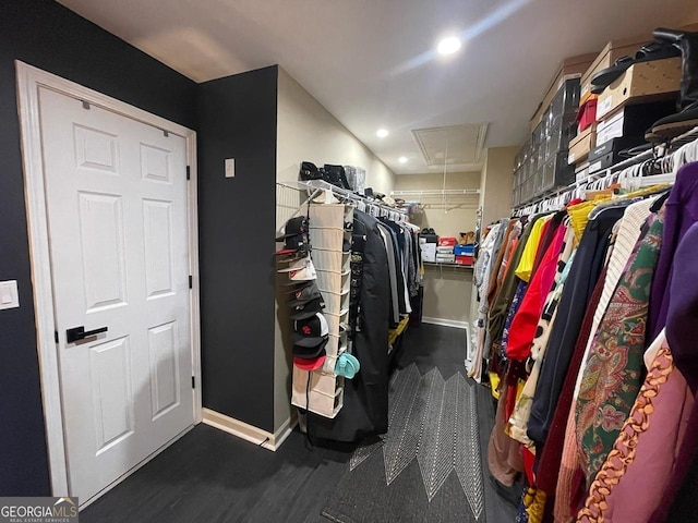 walk in closet featuring attic access and wood finished floors