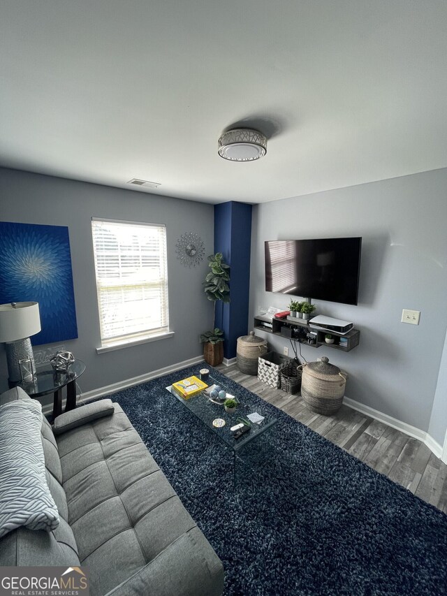 living room with baseboards, wood finished floors, and visible vents