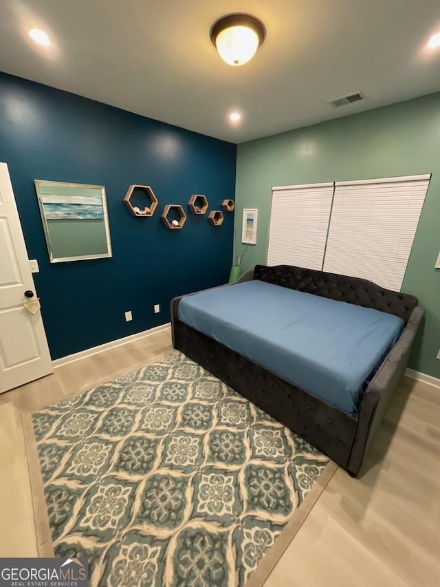 bedroom with baseboards, recessed lighting, wood finished floors, and visible vents