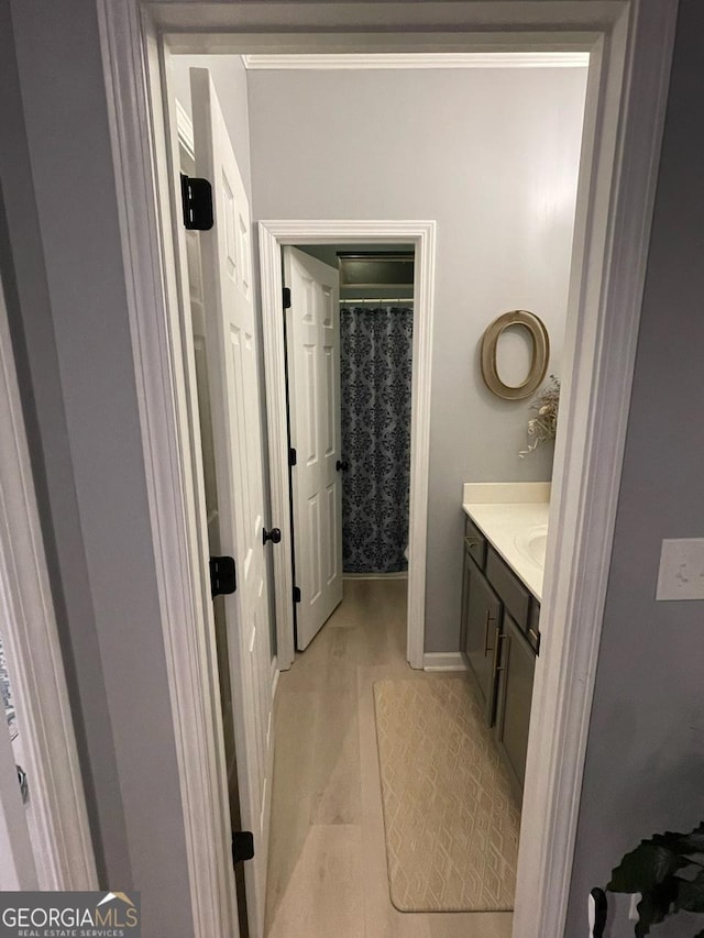 bathroom featuring vanity, baseboards, and curtained shower