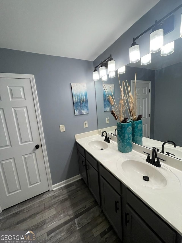 bathroom with a sink, double vanity, and wood finished floors