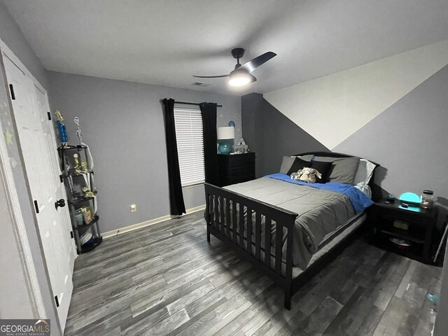 bedroom featuring baseboards, ceiling fan, wood finished floors, and visible vents