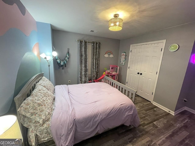 bedroom featuring baseboards, wood finished floors, and visible vents
