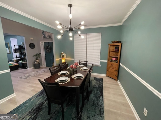 dining area with crown molding, baseboards, a chandelier, and light wood-style floors