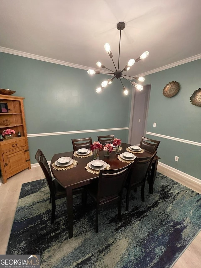 dining space featuring an inviting chandelier, ornamental molding, light wood finished floors, and baseboards