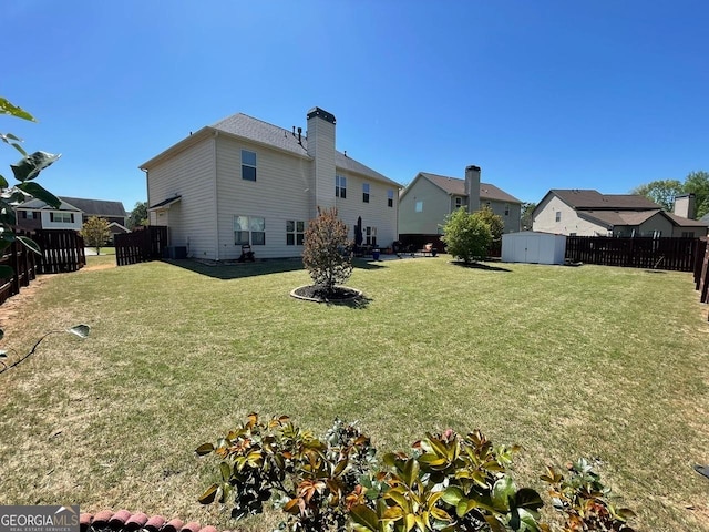 rear view of property with a storage unit, an outdoor structure, a lawn, and a fenced backyard
