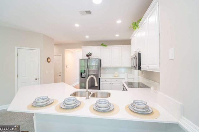 3819 Meandering Way SW, Lilburn, GA 30047 - kitchen featuring a sink, appliances with stainless steel finishes, a peninsula, white cabinetry, and visible vents
