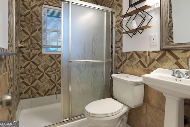 full bath featuring a shower stall, tile walls, and toilet