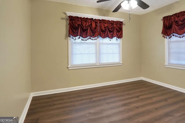 unfurnished room with ceiling fan, a wealth of natural light, baseboards, and dark wood-style flooring