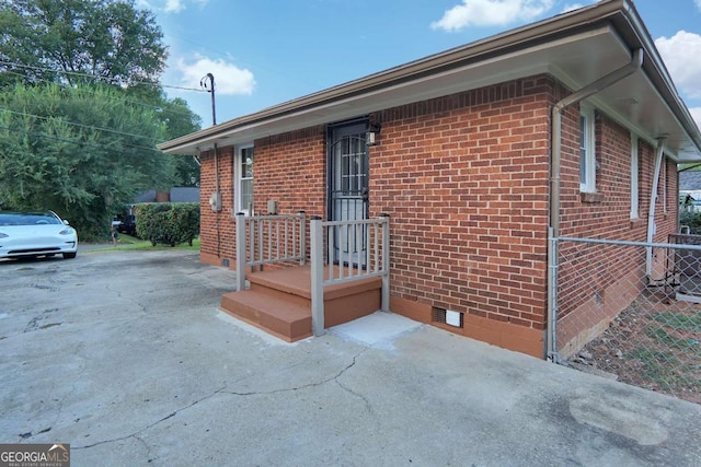 view of home's exterior featuring brick siding, central AC unit, crawl space, and fence