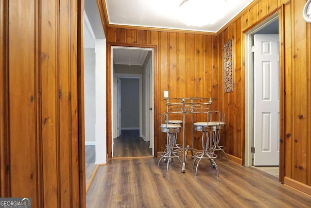 dining area with wood walls, attic access, baseboards, and wood finished floors