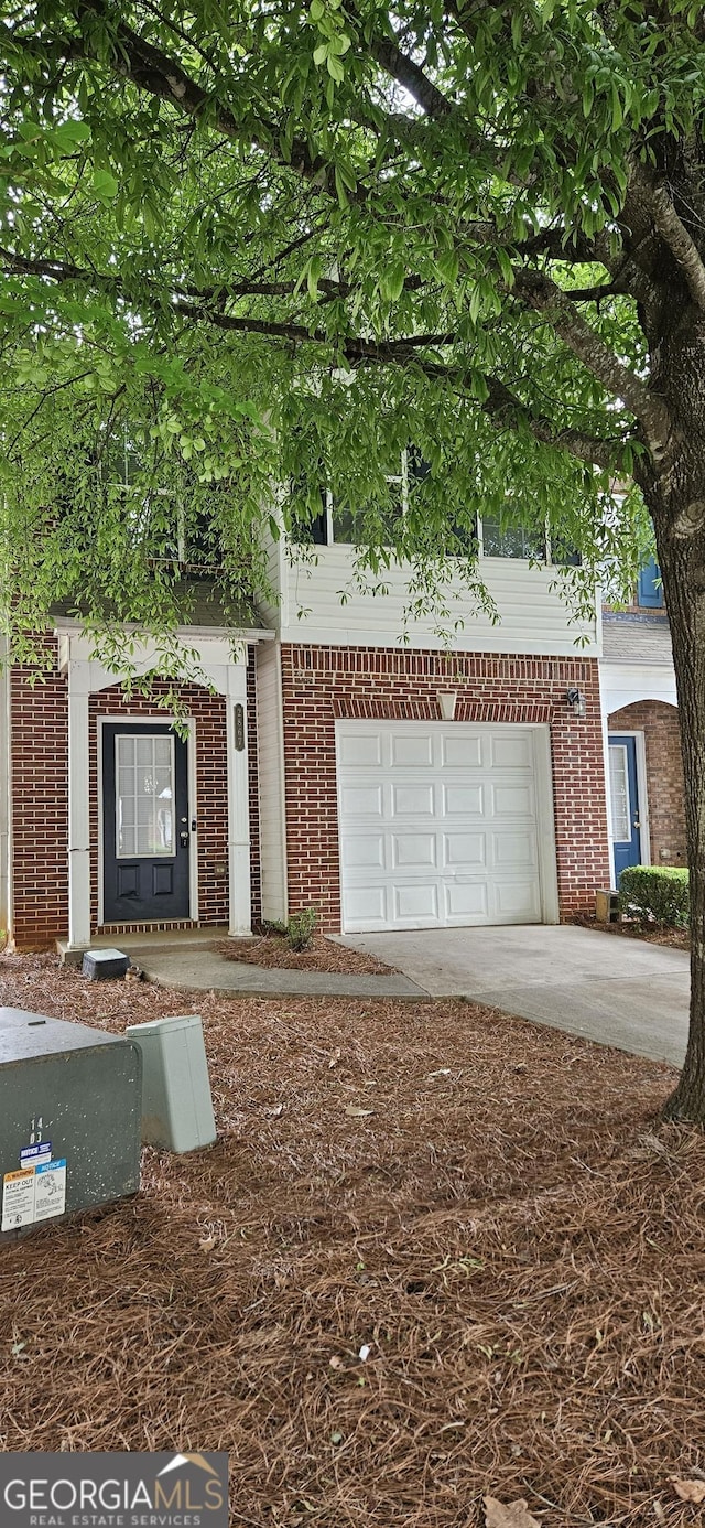 2867 Snapfinger Mnr, Decatur, GA 30035 - view of property hidden behind natural elements with brick siding, a garage, and concrete driveway
