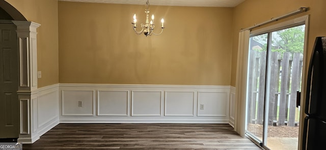 2867 Snapfinger Mnr, Decatur, GA 30035 - unfurnished dining area featuring ornate columns, an inviting chandelier, arched walkways, dark wood-type flooring, and a decorative wall