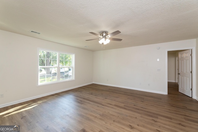 unfurnished room featuring wood finished floors, visible vents, baseboards, and ceiling fan