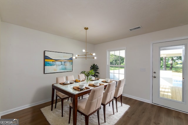 dining room featuring baseboards, dark wood-type flooring, visible vents, and a chandelier