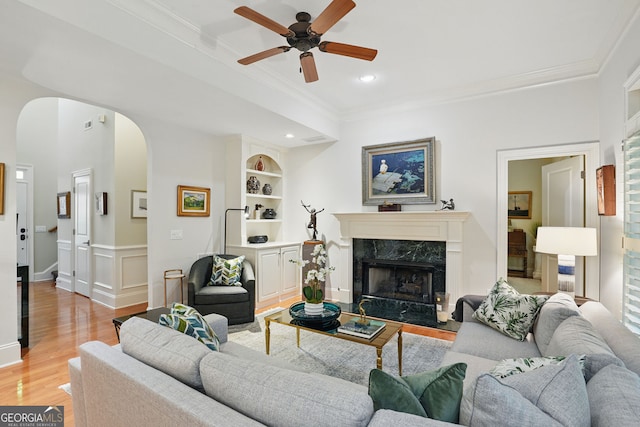 104 Glentown Way, Sandy Springs, GA 30328 - living room featuring a ceiling fan, crown molding, arched walkways, a fireplace, and light wood-type flooring
