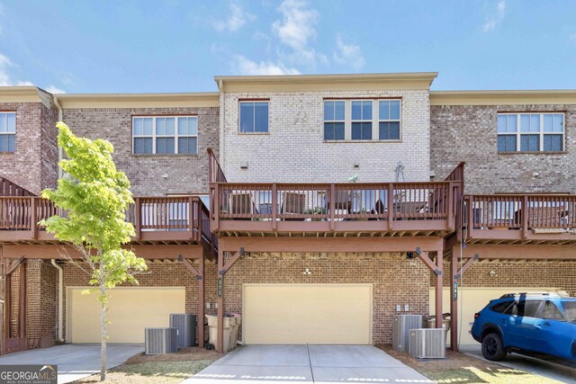 371 Northaven Ave, Suwanee, GA 30024 - back of house with brick siding, an attached garage, driveway, and central air condition unit