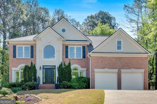 colonial home with brick siding, driveway, and a front yard
