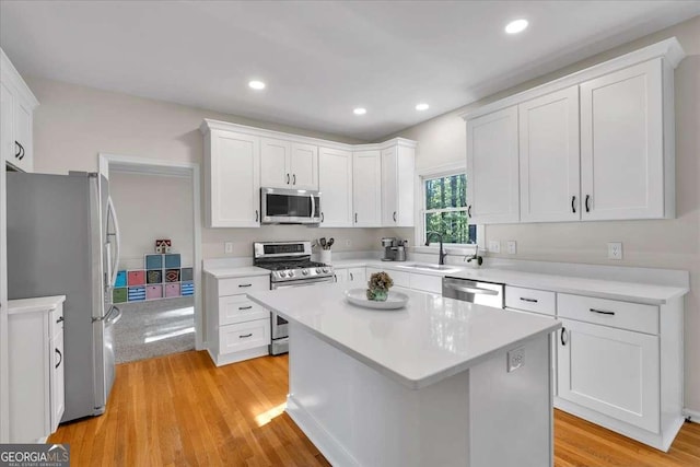 kitchen featuring white cabinets, appliances with stainless steel finishes, a sink, and light countertops