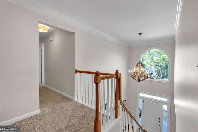 interior space featuring carpet, baseboards, a notable chandelier, and an upstairs landing
