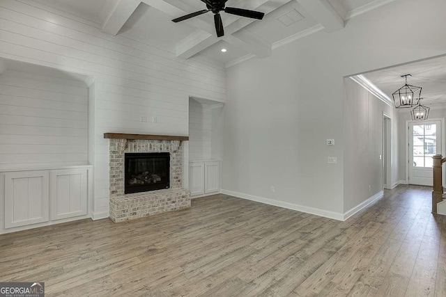 unfurnished living room with light wood-style floors, beamed ceiling, a chandelier, ceiling fan, and baseboards