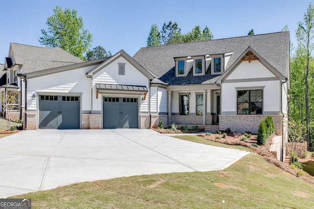 modern farmhouse with an attached garage, concrete driveway, brick siding, and a shingled roof