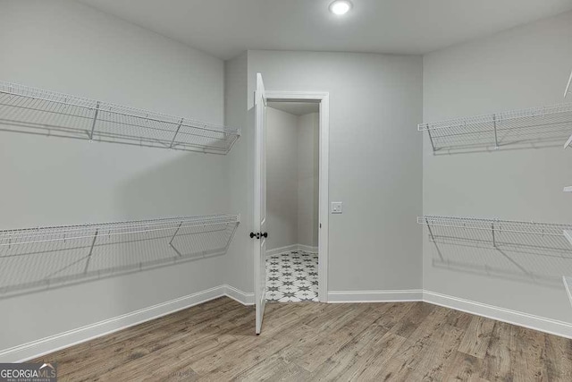 walk in closet with wood finished floors