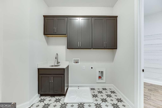 washroom with electric dryer hookup, cabinet space, hookup for a washing machine, light floors, and baseboards