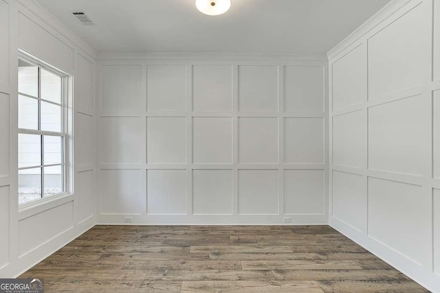 empty room featuring a decorative wall and wood finished floors