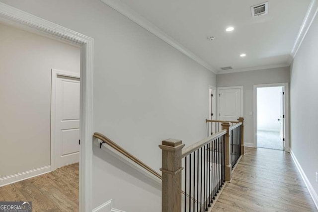 hall with an upstairs landing, light wood-type flooring, recessed lighting, crown molding, and baseboards