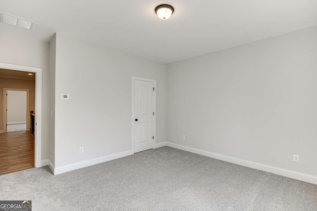 spare room featuring carpet flooring and baseboards