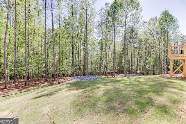 view of grassy yard featuring a view of trees