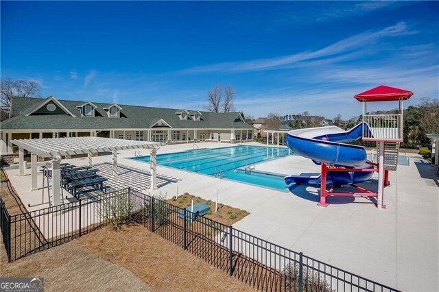 community pool featuring a pergola, fence, a patio, and a water slide