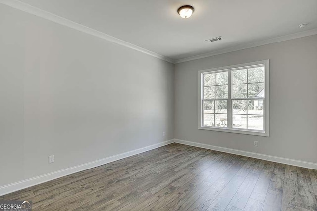 spare room featuring dark wood finished floors, baseboards, and ornamental molding