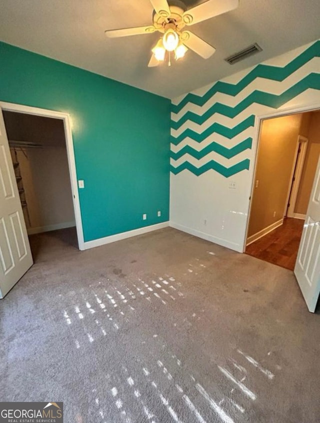 unfurnished bedroom with visible vents, carpet flooring, baseboards, and ceiling fan