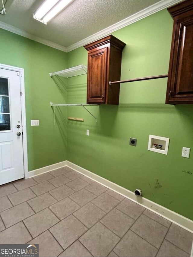 washroom featuring ornamental molding, hookup for an electric dryer, cabinet space, and washer hookup
