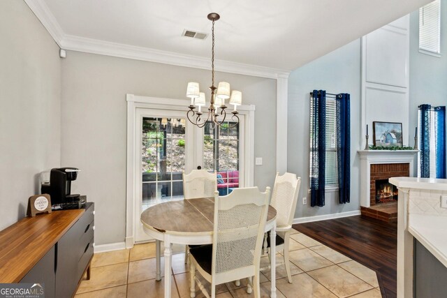 2267 Howell Farms Trl, Acworth, GA 30101 - dining area featuring light tile patterned floors, baseboards, visible vents, a notable chandelier, and ornamental molding