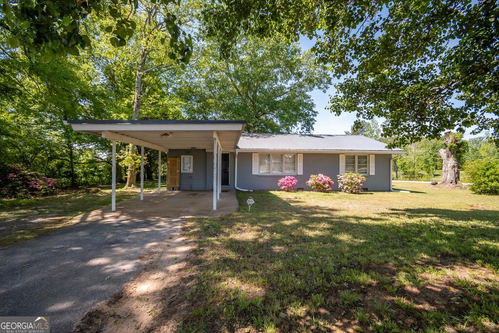 615 Sanford Rd, Hull, GA 30646 - view of front of home featuring a carport, a front lawn, aphalt driveway, and metal roof