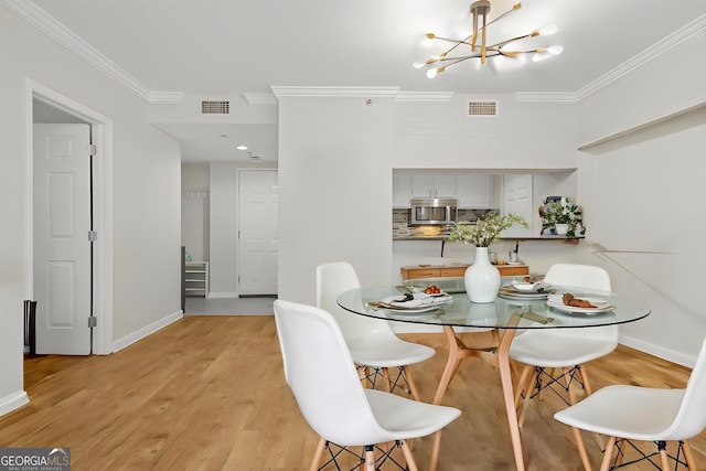 3481 Lakeside Dr NE Unit 601, Atlanta, GA 30326 - dining space with light wood-style flooring, visible vents, a notable chandelier, and crown molding