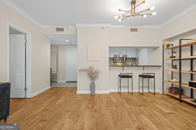 3481 Lakeside Dr NE Unit 601, Atlanta, GA 30326 - dining area with light wood-style flooring, visible vents, an inviting chandelier, and crown molding