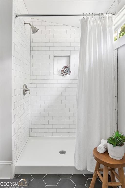bathroom featuring tile patterned flooring and a stall shower