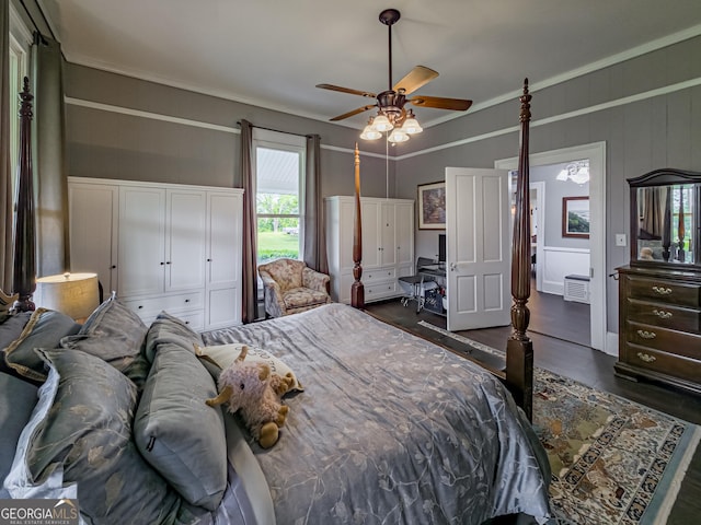 bedroom featuring ceiling fan, ornamental molding, and dark wood-type flooring