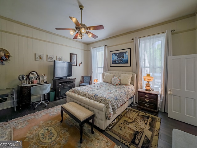 bedroom featuring a ceiling fan, crown molding, and wood finished floors