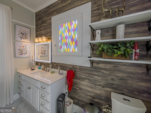 bathroom with crown molding, vanity, wooden walls, marble finish floor, and toilet